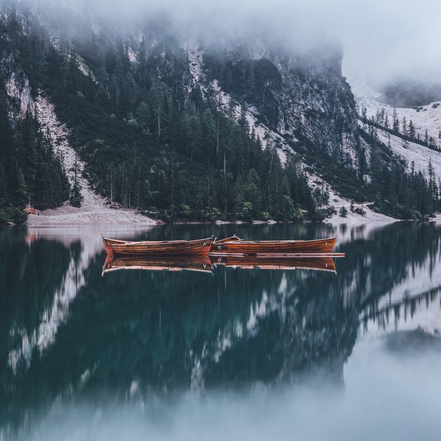 boats-at-calm-body-of-water-by-mountain-slip-2437293.jpg